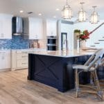 Kitchen remodel includes coastal, modern navy island and white shaker cabinets which creates a breezy welcoming area for a crowd to gather.