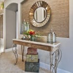 Foyer decor features console table with grasscloth niche. The design style flows from the foyer into the living room.
