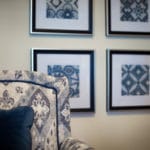 Upholstered tapestry chair with contrasting welt; with framed prints