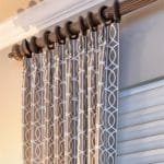 Drapes in modern geometric fabric with cellular window shades