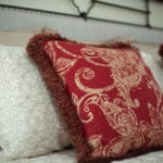 Gorgeous paisley tapestry pillows with brush fringe detail accent this iron bed frame.