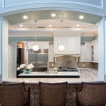 This renovated kitchen is more open to the living room with upper cabinets removed from the pass through showing the expansive space with a double island.