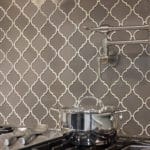 Client's existing gas cook top stands out against the new glass mosaic tile in two shades of taupe. The addition of a pot filler makes the space ready for the next past party!